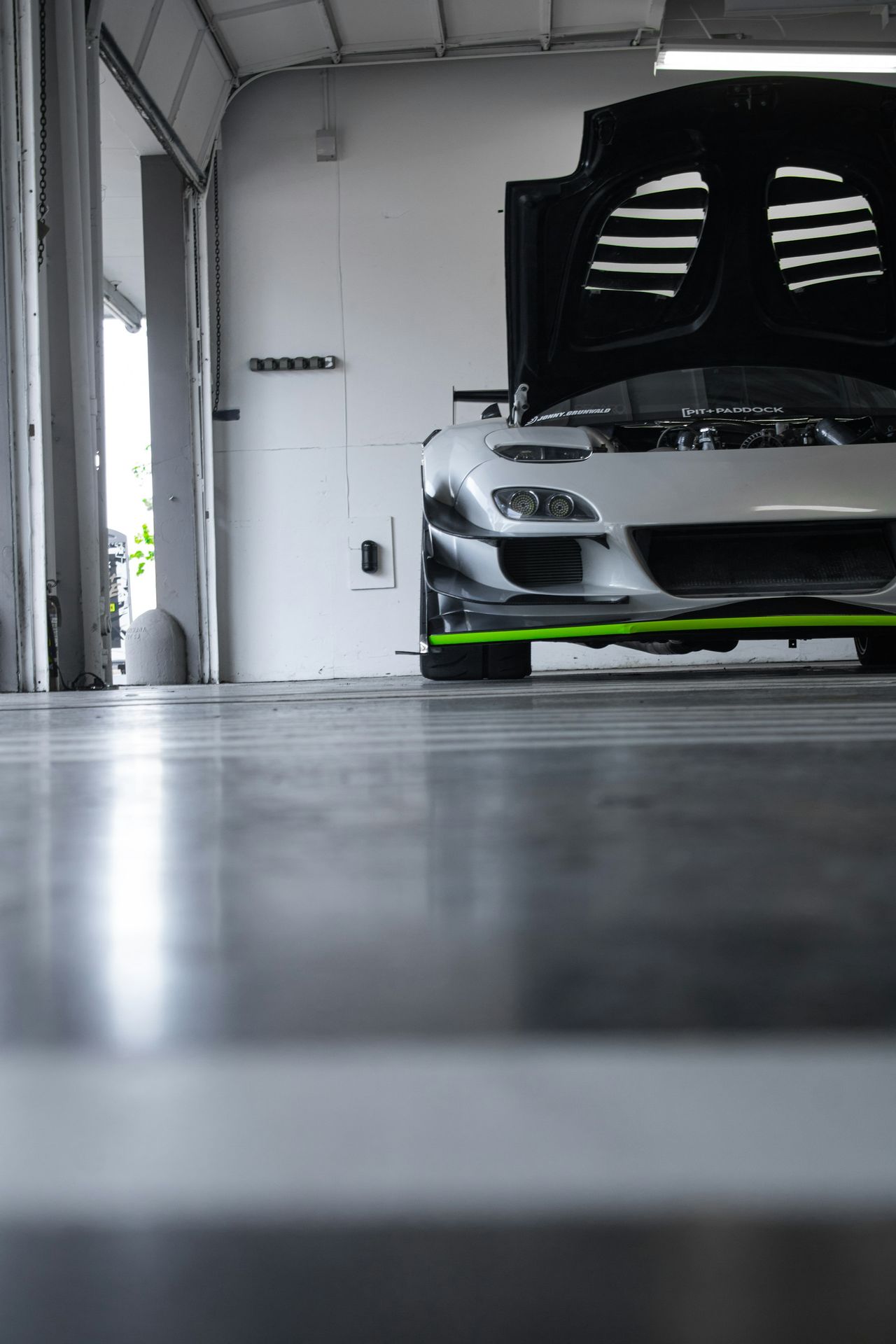a car parked in a garage with its hood open
